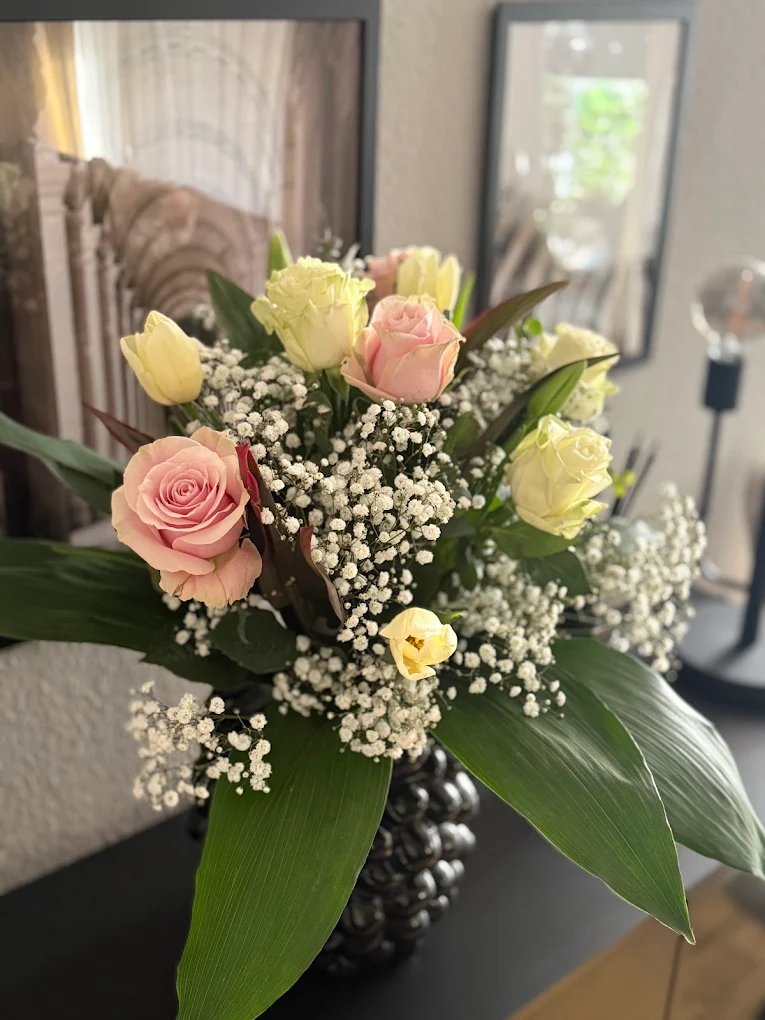 Handgebundener Strauß aus rosa und cremefarbenen Rosen mit Schleierkraut