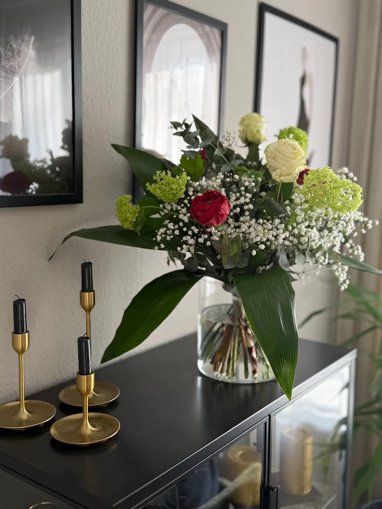Strauß mit weißen Rosen, roter Ranunkel und Viburnum in Glasvase